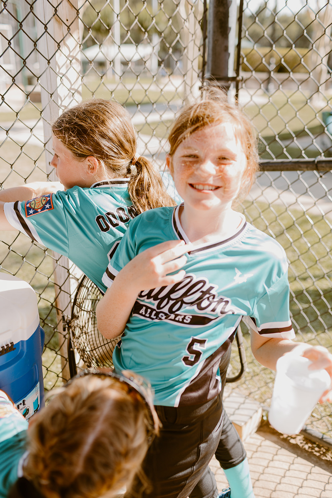 Bluffton All-Star player smiling near the dugout fence