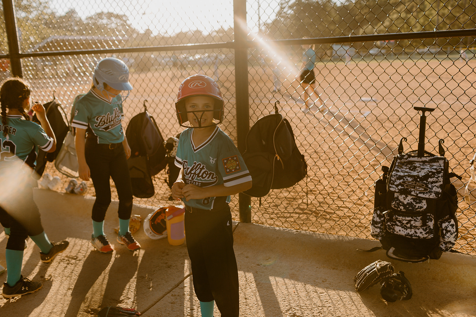 Bluffton All-Star player ready to bat in the sunlit dugout