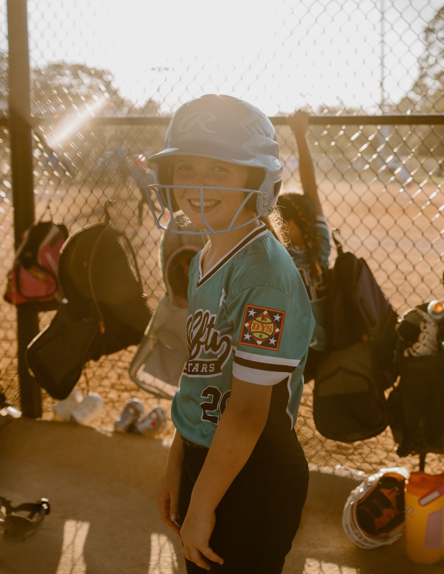 Bluffton All-Star player smiling in her batting helmet in the dugout